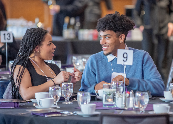 Two students sitting at a table talking