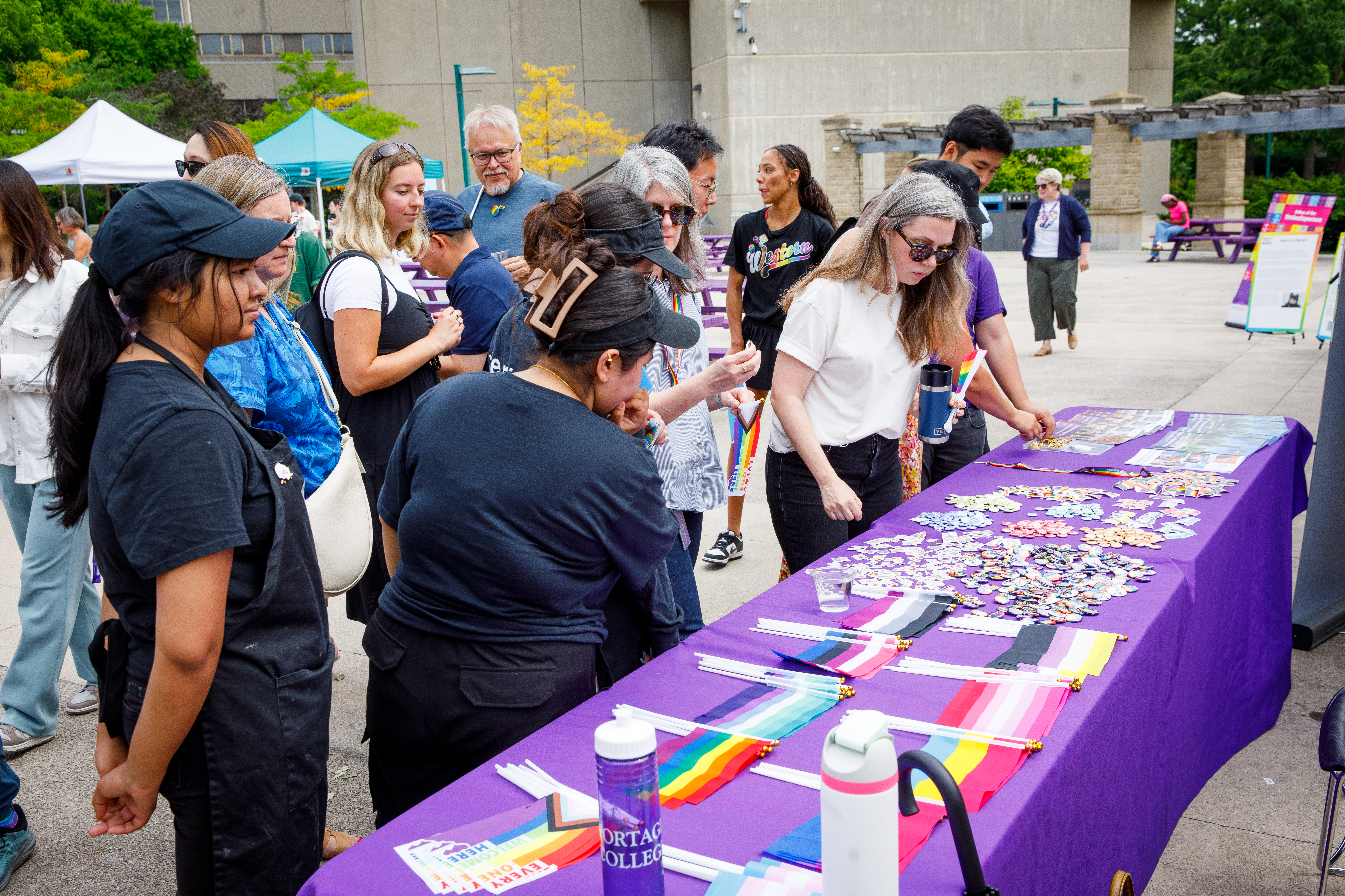 Many people examine a purple resource table and pick up free merchandise like buttons, pins, flags and booklets.