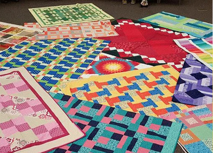 A photo of colourful blankets on the floor.